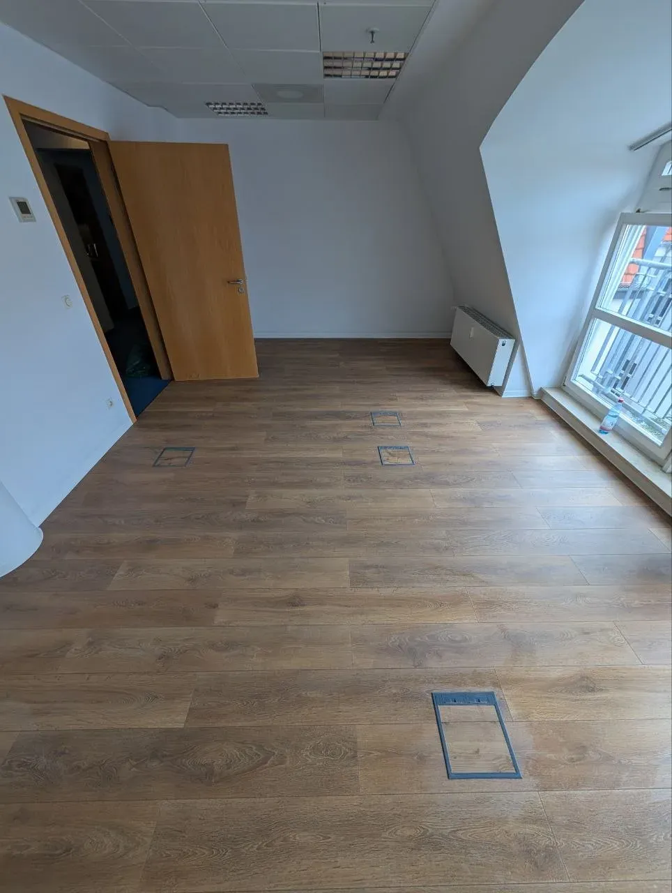Neu verlegtes Laminat im Büro mit Bodentanks und Anschluss an die Dachschräge