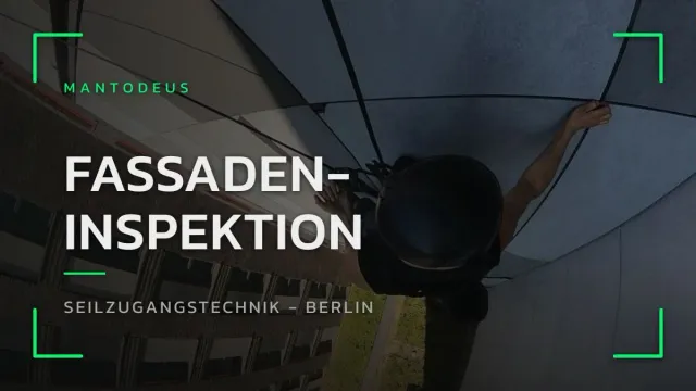 Blick von oben auf einen Industriekletterer, der sich zur Fassadeninspektion an einem Bürogebäude in Berlin abseilt
