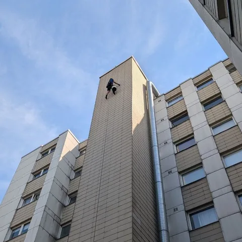 Seilzugangstechniker bei der Reparatur der Fassadenverkleidung an einem Berliner Hochhaus